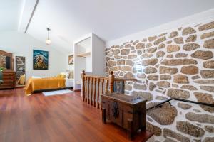 pared de piedra en una sala de estar con escalera en Gerês Escape Retreat - Casa da Fonte de Pedra en Vieira do Minho