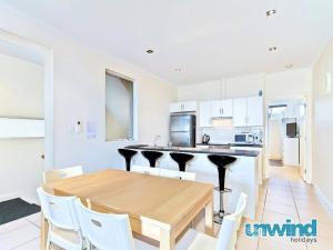 uma cozinha e sala de jantar com uma mesa de madeira e cadeiras em Block Escape - Ocean View Apartment No 1 em Victor Harbor