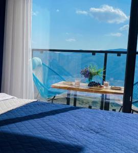 een slaapkamer met een bed en een tafel en uitzicht bij Twins apartment deluxe, new gudauri in Goedaoeri