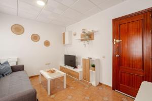 a living room with a couch and a tv and a table at Apartamento playa del Carmen in Barbate