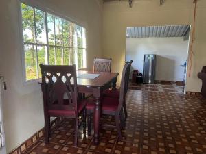 comedor con mesa, sillas y ventana en Rancho Agua Fria casa, en Usulután