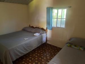 a small bedroom with two beds and a window at Rancho Agua Fria casa in Usulután