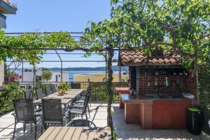 un patio con mesa y sillas y una cocina al aire libre. en Apartments Villa Ivanka, en Trogir