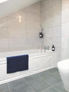 Luxury 2 Bed, 2 Bath Apartment in Central Watford في واتفورد: حمام مع حوض استحمام ومرحاض