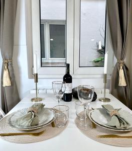 a table with plates and glasses and a bottle of wine at 1571 - Louvre studio in Paris Olympic Games 2024 in Paris