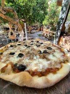 a pizza with olives and cheese on a table at Litost Cafe Bungalow in Adrasan