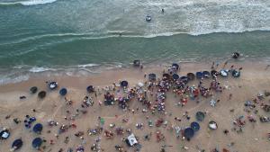 una folla di persone su una spiaggia con ombrelloni di Blue sea motel a Thăng Bình