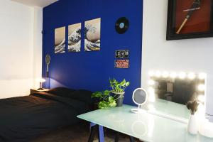 um quarto com uma parede azul com uma cama e uma mesa em Blue Note Apartment em Montesilvano