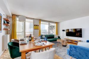een woonkamer met een tafel en een bank bij 825 Suite Bacla - Superbe appartement in Courbevoie