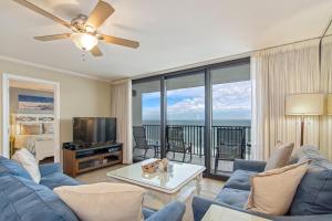 a living room with a blue couch and a tv at One Seagrove Place 0908 in Santa Rosa Beach