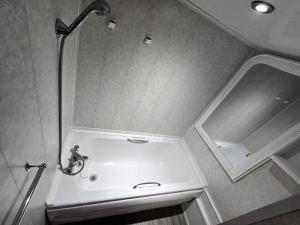 a bathroom with a shower and a sink with a mirror at Wilsons Lodge in Blackpool