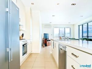 a kitchen with white cabinets and white appliances at The Block Escape - Ocean Views No 6 in Victor Harbor