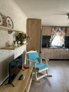 a living room with a tv and a blue chair at Άνεμος Home in Elaiokhórion