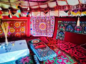 a bed with colorful blankets and pillows on it at Юрта Qyran in Türgen