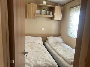Kleines Zimmer mit einem Bett und einem Fenster in der Unterkunft 3 Bed Caravan Lido Beach in Prestatyn