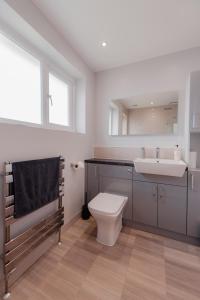 ein Badezimmer mit einem Waschbecken, einem WC und einem Spiegel in der Unterkunft Luxury Recently Renovated 3 Bedroom home in Sandwich Kent in Sandwich