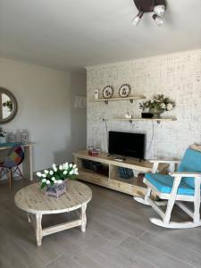 a living room with a tv and chairs and a table at Άνεμος Home in Elaiokhórion