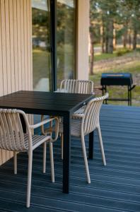 een zwarte tafel en twee stoelen op een veranda bij Chill Hill Kalviai 