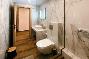 uma casa de banho com um WC, um lavatório e um chuveiro em Downtown Opalio Apartments em Kavala