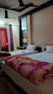MajuliにあるHotel Srimanta sankardevのベッドが2つと窓があるホテルの部屋