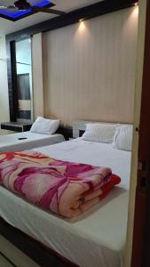 dos camas sentadas una al lado de la otra en una habitación en Hotel Srimanta sankardev, en Majuli