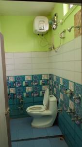 a bathroom with a toilet and a camera on the wall at Hotel Srimanta sankardev in Majuli +9 photos