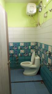 baño con aseo y una cámara en la pared en Hotel Srimanta sankardev, en Majuli