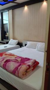 two beds sitting next to each other in a room at Hotel Srimanta sankardev in Majuli