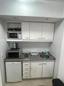 una pequeña cocina con fregadero y microondas en Montmartre Monserrat Buenos Aires en Buenos Aires