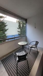 une chambre avec deux chaises, une table et une fenêtre dans l'établissement Upea saunallinen kolmio, à Nokia