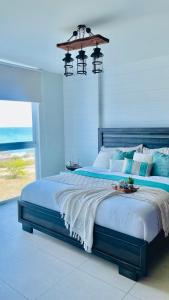 a bedroom with a large bed with a view of the ocean at Exclusivo, Moderno y Cómodo Apto temático con hermosa Vista al Mar in Playa Blanca