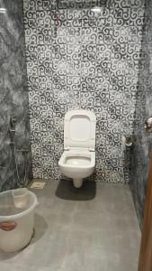 uma casa de banho com WC e papel de parede preto e branco em Golden View Dormitory em Mumbai