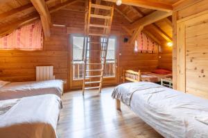 a log cabin with two beds and a ladder at Auberge du coin in Saint-Colomban-des-Villards