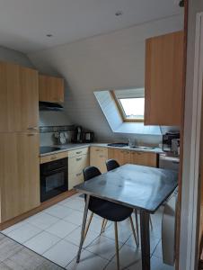 a kitchen with a table and chairs and a window at Le Cosy in Lanvallay