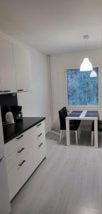 een keuken met een tafel en een tafel en een eetkamer bij Upea saunallinen kolmio in Nokia