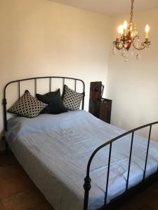 波爾托瓦爾特拉瓦利亞的住宿－Appartamento Ibisco，一间卧室配有一张带枕头的床和吊灯。