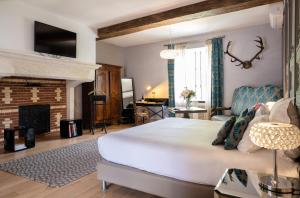 um quarto com uma cama grande e uma lareira em Château de Melin - B&B em Auxey-Duresses