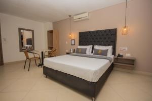 um quarto com uma cama grande e uma mesa em Hotel Perlatto em Bello