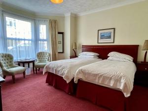 a large bedroom with a large bed and a chair at Bay View - Seafront, Sandown --- Car Ferry Optional Extra 92 pounds Return from Southampton in Sandown