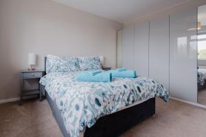 Schlafzimmer mit einem Bett mit einer blauen und weißen Bettdecke in der Unterkunft Luxury Recently Renovated 3 Bedroom home in Sandwich Kent in Sandwich