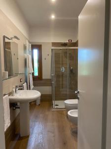 ein Bad mit einer Dusche, einem Waschbecken und einem WC in der Unterkunft Holiday Home Giaron in Rosolina