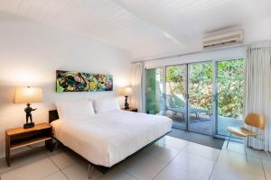 een witte slaapkamer met een bed en een balkon bij Historic Desert Star in Palm Springs +93 foto's