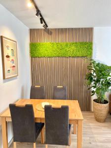 a dining room table with chairs and a green wall at Inselliebe Norderney in Norderney