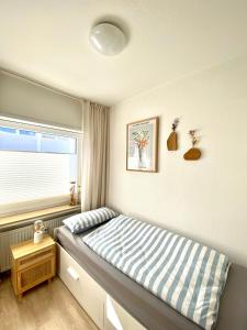 a small bedroom with a bed with a window at Inselliebe Norderney in Norderney