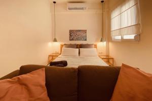 uma sala de estar com uma cama e um sofá em Downtown Opalio Apartments em Kavala