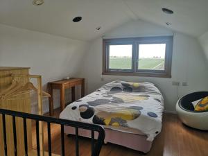 a bedroom with a bed and a window and a tub at Sweet Tiny House in Westbeemster