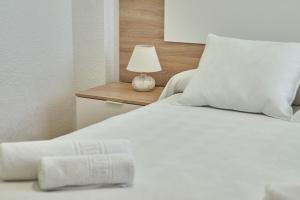 a bed with white sheets and a lamp on a table at Lux Buenavista in Toledo
