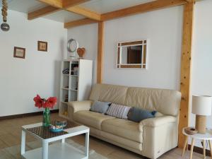 ein Wohnzimmer mit einem Sofa und einem Tisch in der Unterkunft Marina Oceano in La Mareta