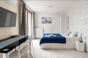 ワルシャワにあるMOKO Apartment IIのベッドルーム(ベッド1台、デスク、テレビ付)