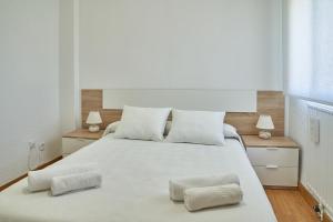 a bedroom with a large white bed with two pillows at Lux Buenavista in Toledo